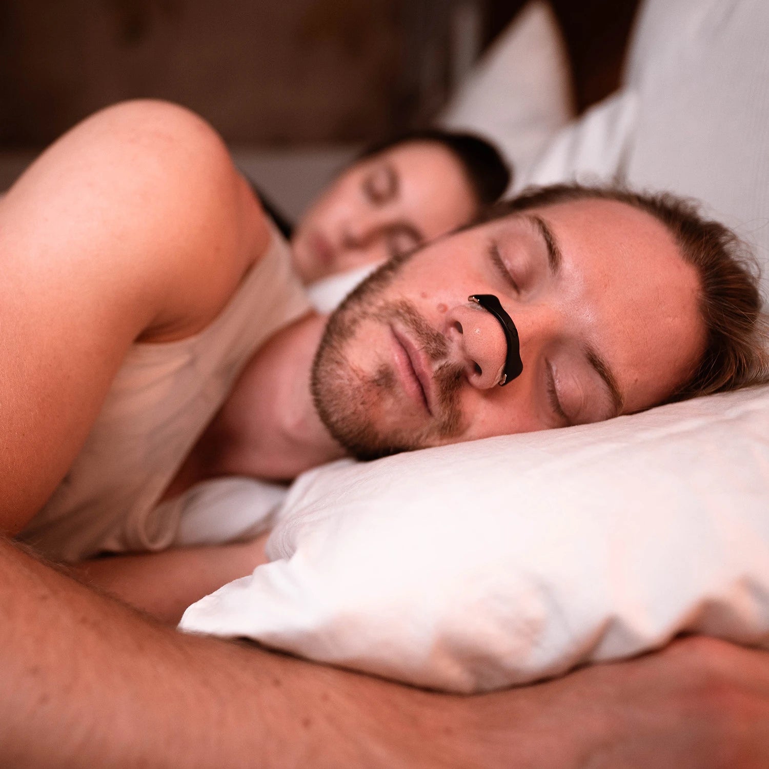 Egy férfi, aki alváshoz használja a légzéskönnyítő orrtapaszt és sokkal jobban alszik miatta.