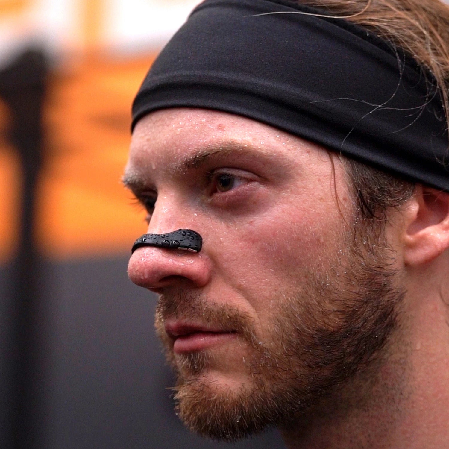 Egy férfi sportoló aki légzékönnyítő orrtapaszt használ a sportoláshoz.